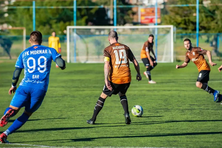 Comment les clubs européens recrutent les futurs talents du football ? 3 Joueurs de football en action, un joueur porte le numéro 99 FK Mornar