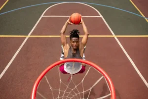 Jeune joueur de basketball en plein saut pour marquer un panier lors d'un entraînement.