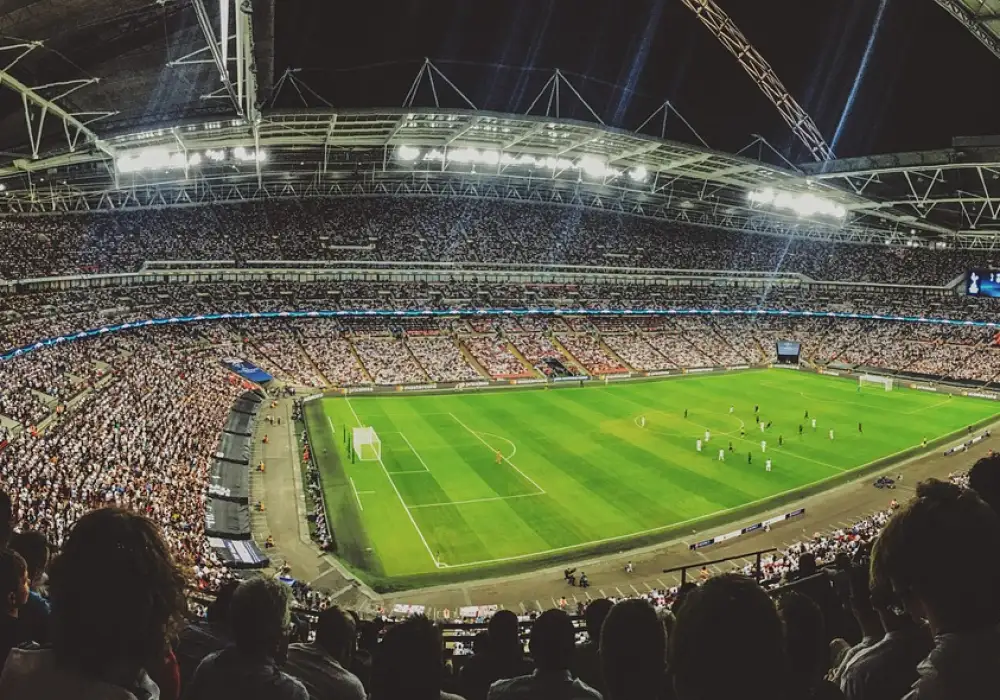 Une foule de supporters remplit les gradins d’un stade de football pendant un match.