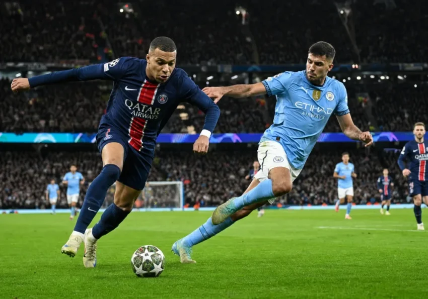 Des joueurs de football pressent haut un défenseur en phase de relance sur un terrain moderne.